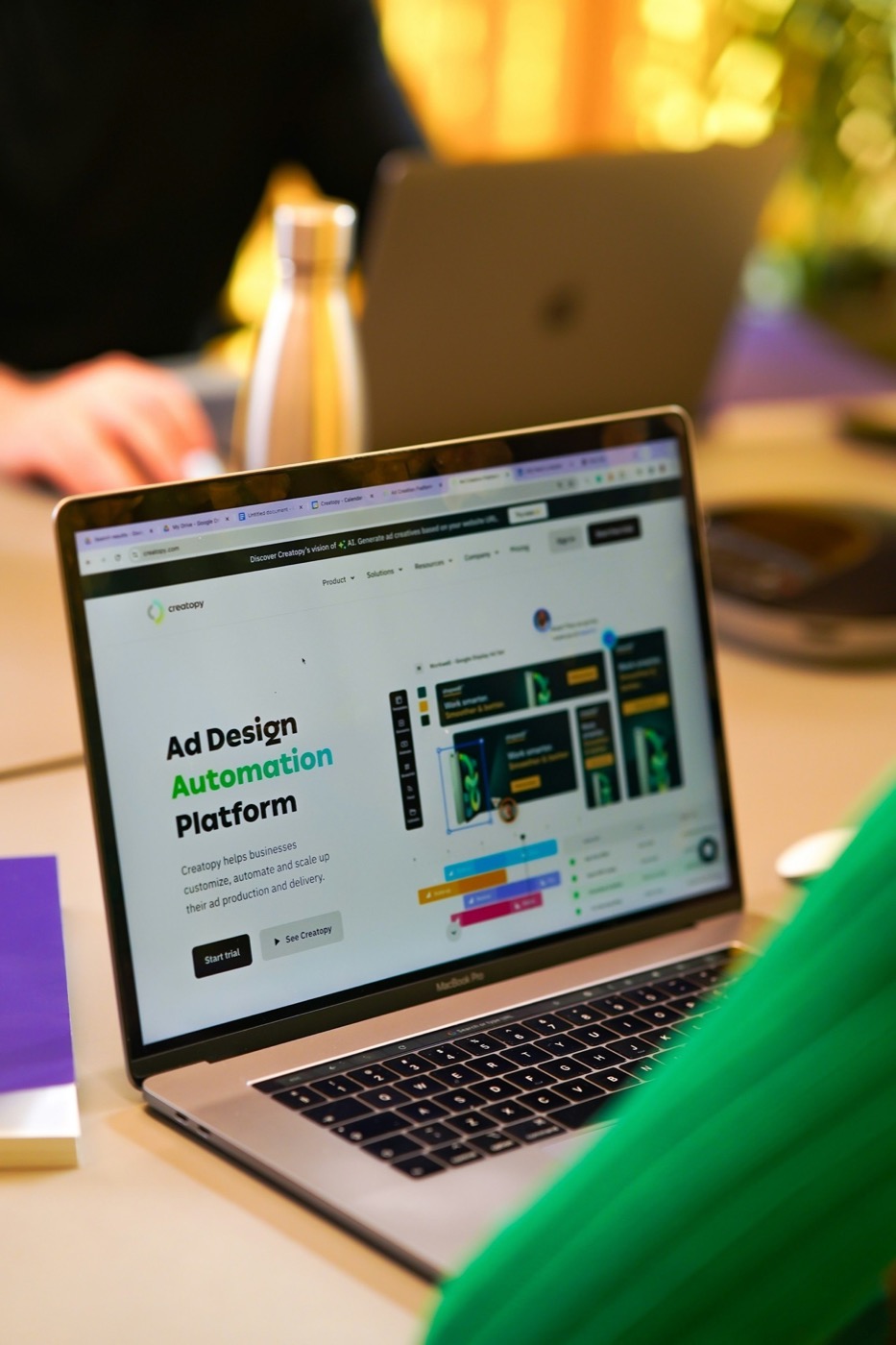 Laptop zeigt die Creatopy-Website mit „Ad Design Automation Platform“ und Beispielen für Werbebanner.